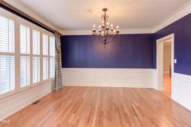 unfurnished room featuring ornamental molding, light hardwood / wood-style floors, and a notable chandelier