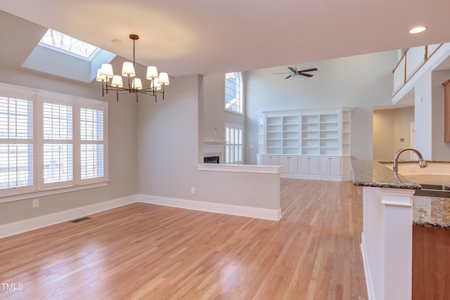 interior space with hanging light fixtures, a wealth of natural light, built in features, and sink