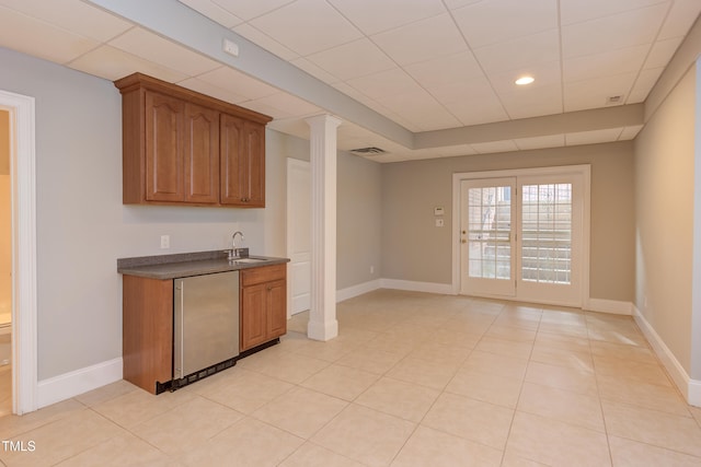 kitchen featuring fridge, light tile patterned flooring, sink, and ornate columns