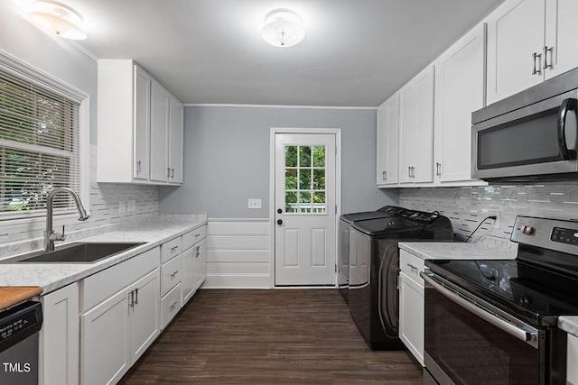 kitchen featuring sink, washer and clothes dryer, stainless steel appliances, dark hardwood / wood-style floors, and white cabinets