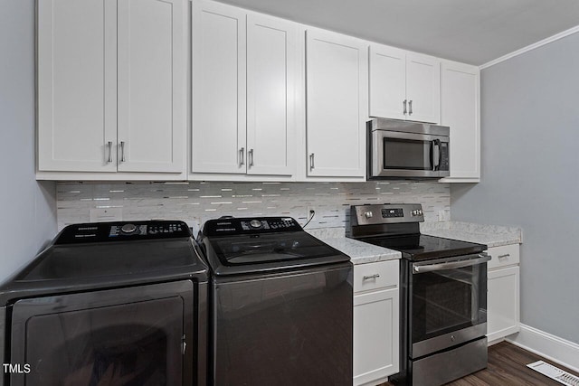 kitchen featuring white cabinetry, stainless steel appliances, washing machine and dryer, and tasteful backsplash