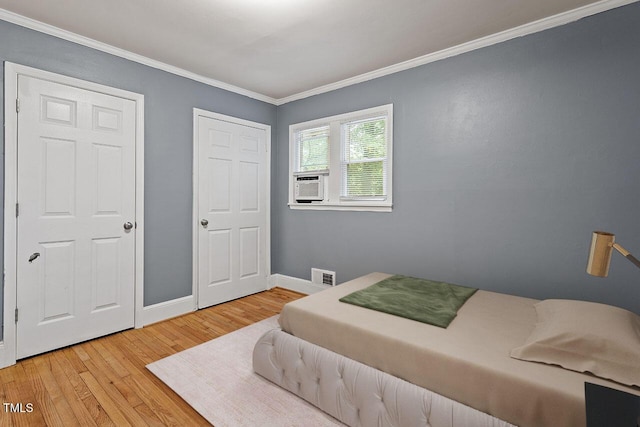 bedroom featuring crown molding, hardwood / wood-style floors, and cooling unit