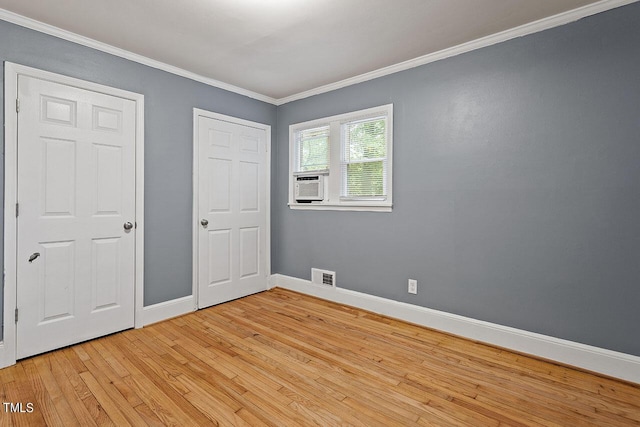 unfurnished bedroom with cooling unit, crown molding, and light hardwood / wood-style floors