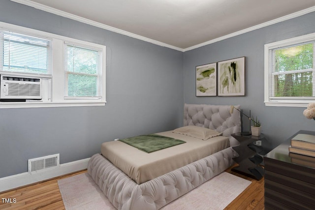 bedroom with multiple windows, cooling unit, crown molding, and hardwood / wood-style flooring