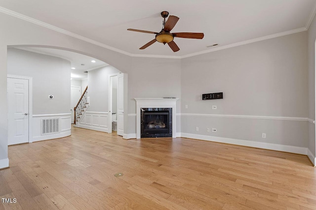 unfurnished living room featuring light wood-style floors, arched walkways, visible vents, and a premium fireplace