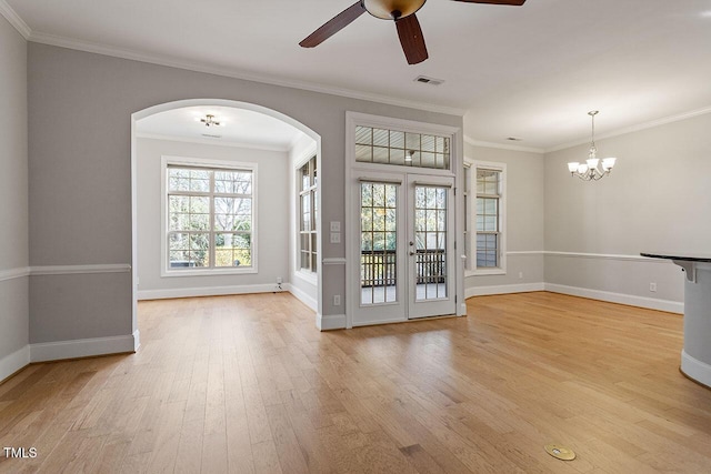 spare room with crown molding, french doors, light hardwood / wood-style floors, and ceiling fan with notable chandelier