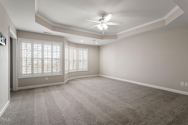 carpeted spare room featuring ceiling fan, ornamental molding, and a tray ceiling