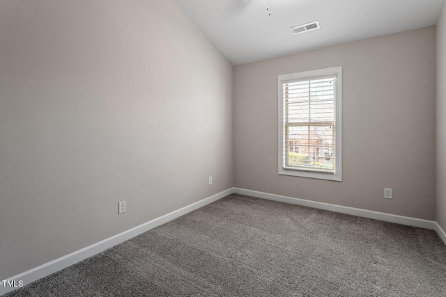 carpeted empty room with lofted ceiling, visible vents, and baseboards