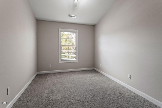 empty room featuring carpet, visible vents, and baseboards