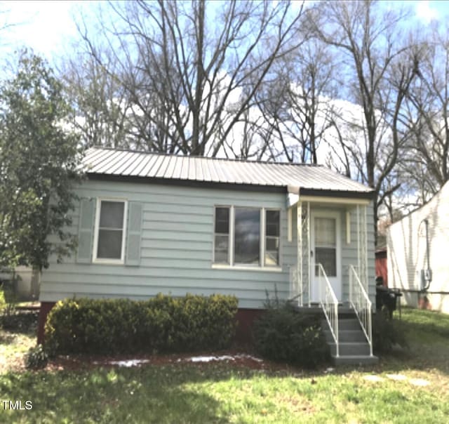 bungalow-style home with a front lawn