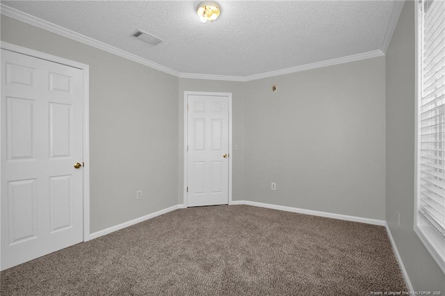 spare room featuring carpet flooring, a textured ceiling, and crown molding