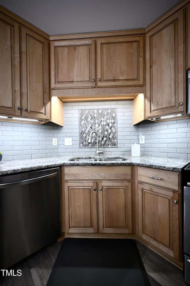 kitchen featuring light stone countertops, dark wood-type flooring, dishwasher, decorative backsplash, and sink