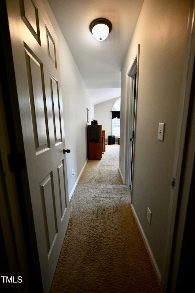 hallway with lofted ceiling and light carpet