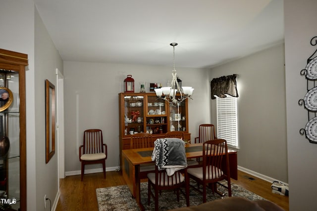 dining room featuring dark wood-type flooring and a notable chandelier