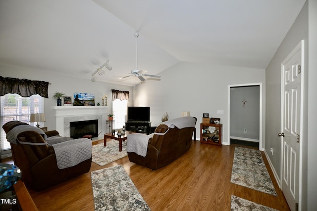 living room with rail lighting, ceiling fan, wood-type flooring, and plenty of natural light