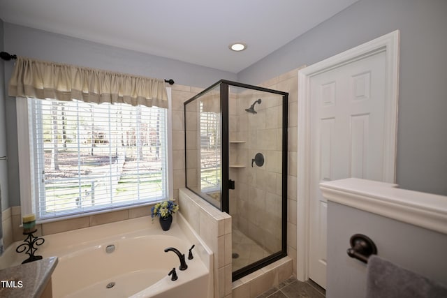 full bathroom featuring a garden tub and a shower stall