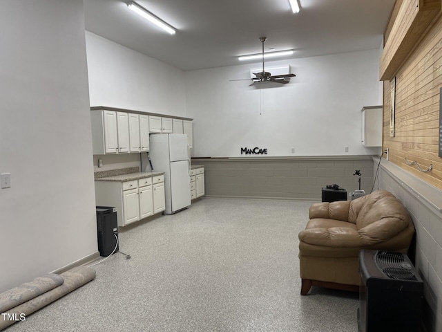 interior space featuring a ceiling fan, white cabinets, open floor plan, light countertops, and freestanding refrigerator