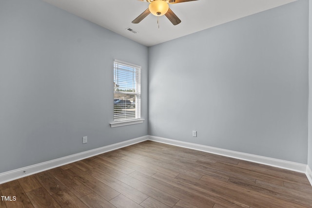 spare room featuring wood finished floors, visible vents, and baseboards