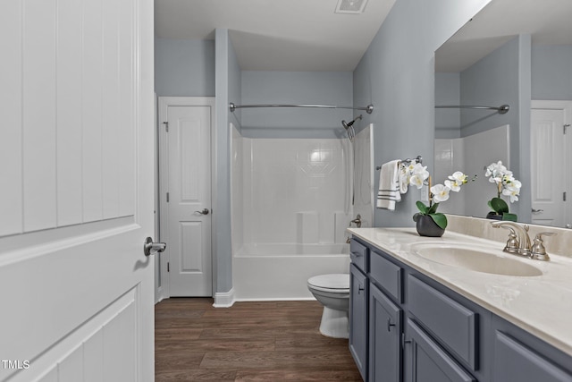 bathroom with toilet, wood finished floors, visible vents, vanity, and shower / bathing tub combination