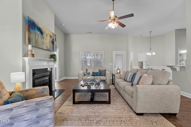 living room with wood finished floors, a glass covered fireplace, and baseboards