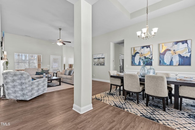 dining space with visible vents, a high ceiling, dark wood-type flooring, baseboards, and ceiling fan with notable chandelier