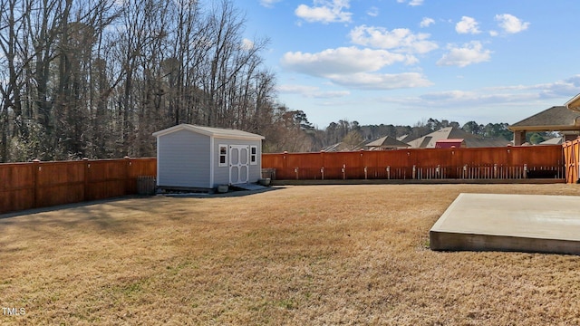 view of yard featuring a fenced backyard, a storage unit, and an outbuilding