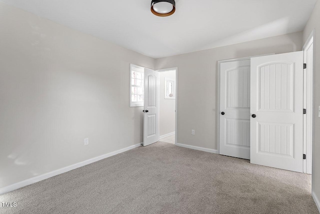 unfurnished bedroom with light colored carpet and a closet