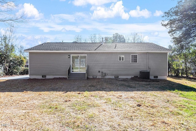 rear view of property featuring a yard and cooling unit