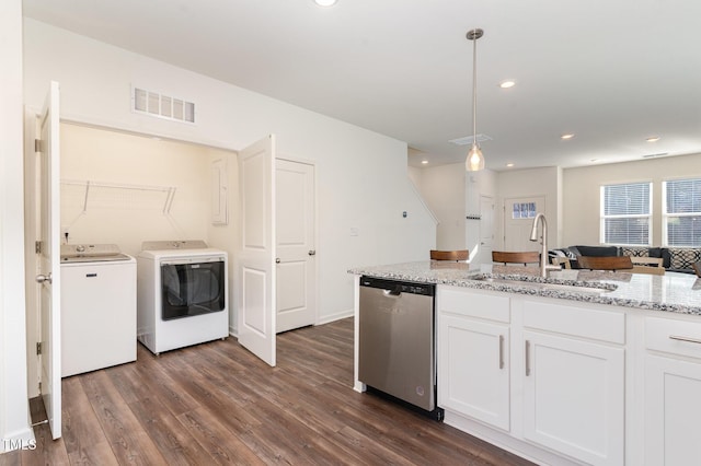 kitchen with dishwasher, washer and dryer, white cabinetry, pendant lighting, and a sink