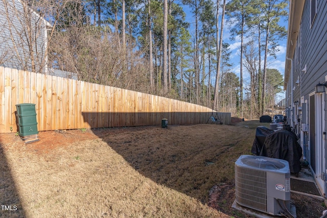 view of yard with fence and central air condition unit