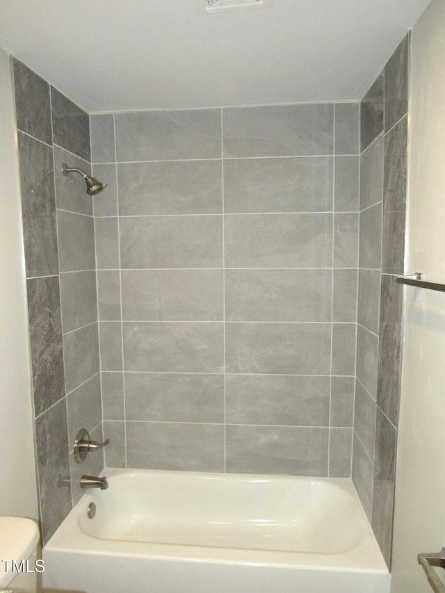 bathroom with tiled shower / bath and toilet