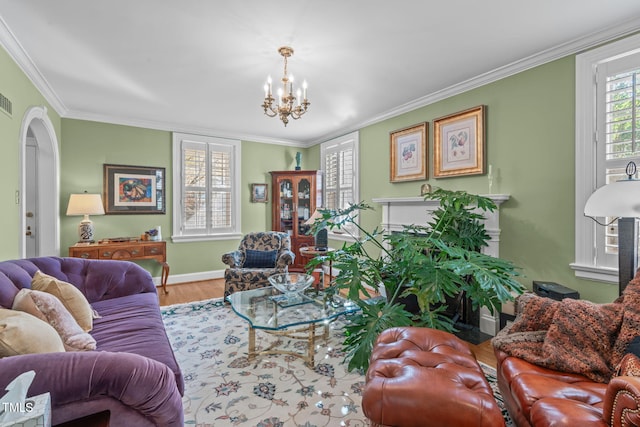 living room featuring ornamental molding, wood-type flooring, a chandelier, and plenty of natural light