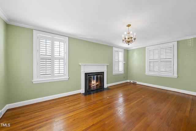 unfurnished living room with crown molding, hardwood / wood-style flooring, and a chandelier