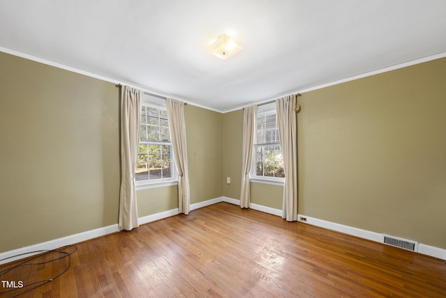 empty room featuring ornamental molding and light hardwood / wood-style flooring