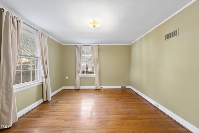 spare room featuring light hardwood / wood-style flooring and crown molding