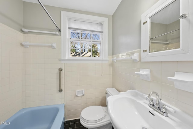 full bathroom with sink, tile walls, toilet, and tiled shower / bath