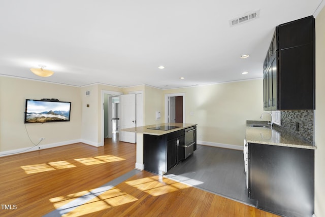 kitchen featuring black electric stovetop, sink, backsplash, dark hardwood / wood-style floors, and ornamental molding