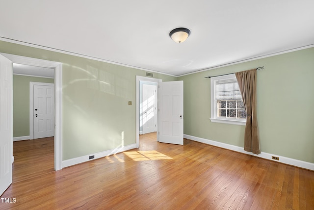 unfurnished bedroom featuring crown molding and light hardwood / wood-style floors