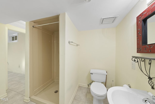 bathroom with a shower, tile patterned floors, and toilet