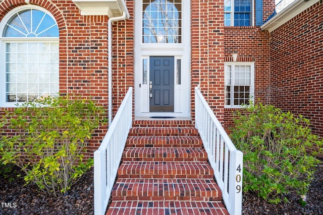 entrance to property featuring brick siding