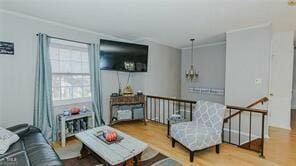 living room with ornamental molding and hardwood / wood-style floors