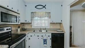 kitchen featuring stainless steel appliances, white cabinetry, and sink