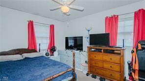 bedroom featuring multiple windows and ceiling fan