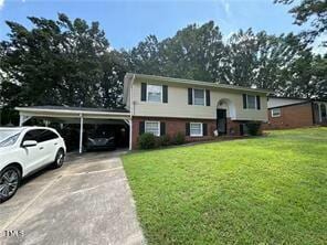 raised ranch featuring a carport and a front lawn