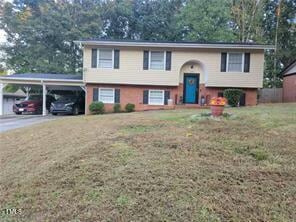 bi-level home featuring a carport and a front lawn