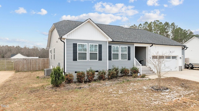 view of front of house with a garage, cooling unit, and a front lawn