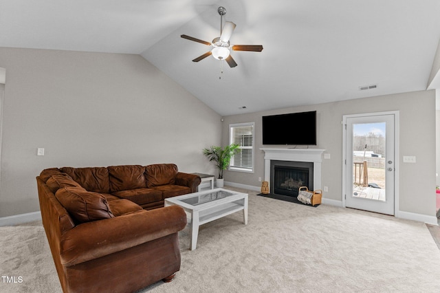 carpeted living room with ceiling fan, vaulted ceiling, and a wealth of natural light