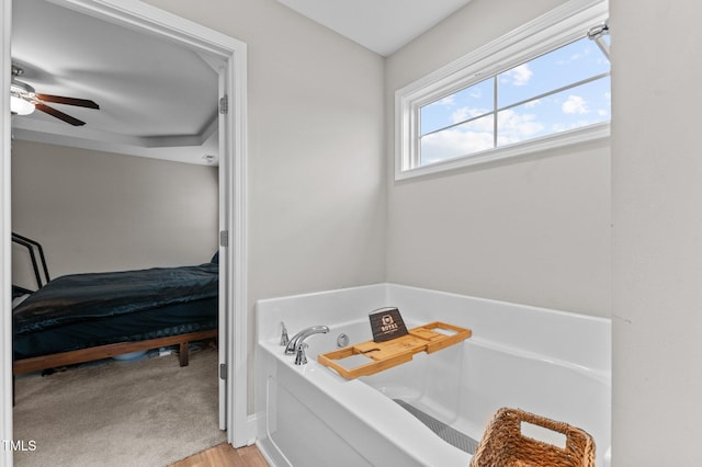 bathroom with a bathing tub and ceiling fan