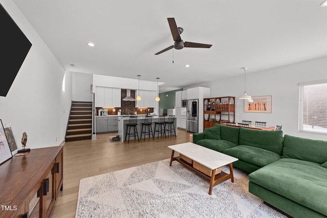 living room featuring ceiling fan and light wood-type flooring