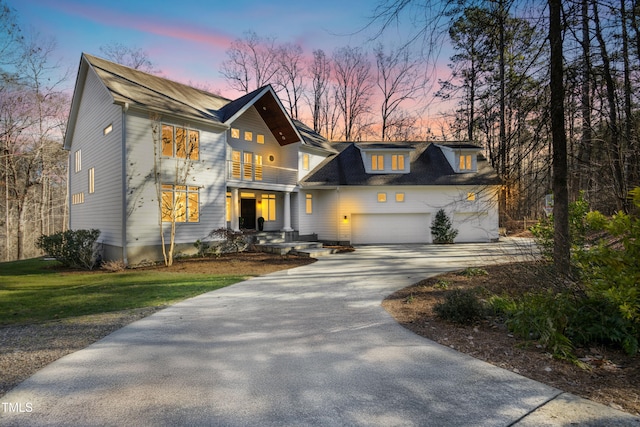 view of front of home featuring a balcony, a garage, and a yard